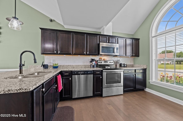 1763 Oak Pointe Dr, Greenville, NC 27834 - kitchen featuring stainless steel appliances, vaulted ceiling, a sink, plenty of natural light, and light stone countertops