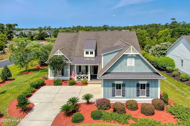 4277 Kingston Ct, Southport, NC 28461 - view of front facade with board and batten siding, a standing seam roof, covered porch, metal roof, and a front yard