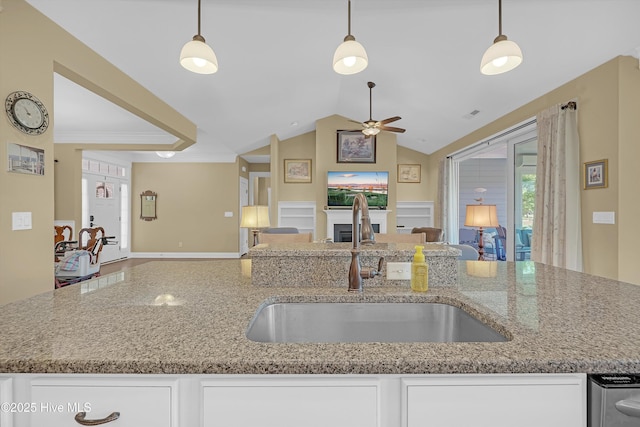 4277 Kingston Ct, Southport, NC 28461 - kitchen with open floor plan, a ceiling fan, a sink, a fireplace, and light stone countertops