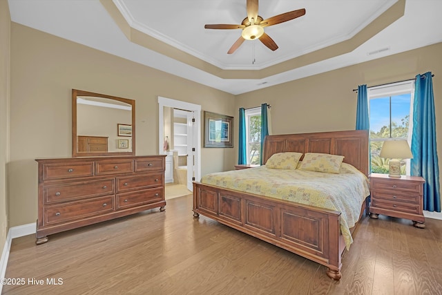 4277 Kingston Ct, Southport, NC 28461 - bedroom with a raised ceiling, light wood-style flooring, ornamental molding, ensuite bath, and ceiling fan