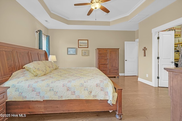 4277 Kingston Ct, Southport, NC 28461 - bedroom with a tray ceiling, wood finished floors, ornamental molding, ceiling fan, and baseboards