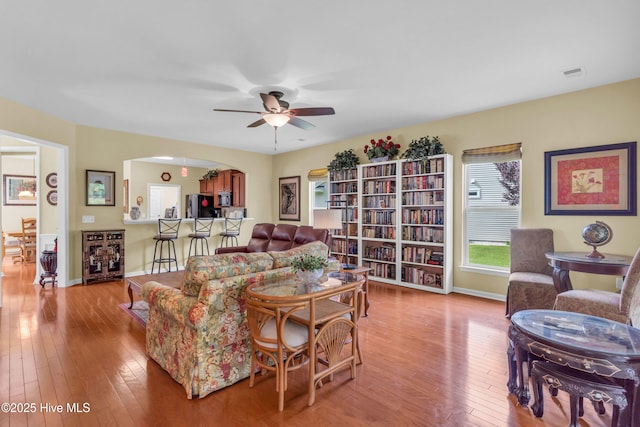 5170 Swashbuckler Way, Southport, NC 28461 - living room featuring ceiling fan, hardwood / wood-style floors, baseboards, and arched walkways