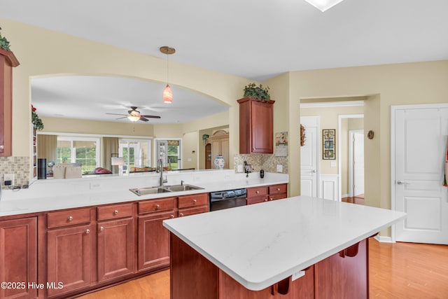 5170 Swashbuckler Way, Southport, NC 28461 - kitchen with a sink, black dishwasher, arched walkways, decorative backsplash, and light wood finished floors