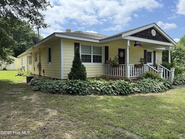 9439 Clayton Blvd, Clayton, NC 27520 - view of front of house with covered porch, ceiling fan, a front lawn, and a chimney