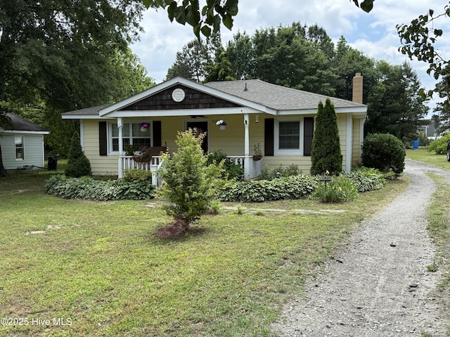 9439 Clayton Blvd, Clayton, NC 27520 - bungalow-style home with a chimney, driveway, covered porch, a front lawn, and a shingled roof