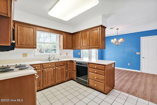 321 Santa Ana Dr, Wilmington, NC 28412 - kitchen featuring black dishwasher, a sink, a chandelier, brown cabinetry, and a textured ceiling