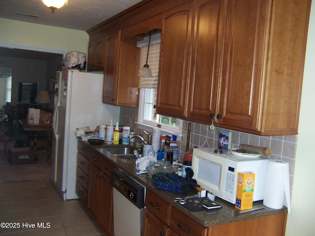 125 Pinehurst Trace Dr, Pinehurst, NC 28374 - kitchen with white appliances, a sink, brown cabinetry, and decorative backsplash
