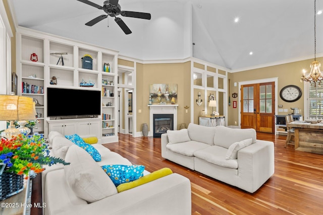401 Fire Fly Ln, Southport, NC 28461 - living room with a glass covered fireplace, wood finished floors, a ceiling fan, a chandelier, and recessed lighting