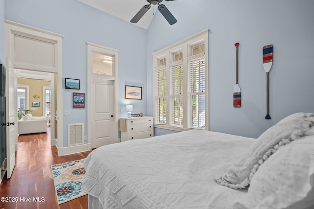 401 Fire Fly Ln, Southport, NC 28461 - bedroom with multiple windows, dark wood-style flooring, vaulted ceiling, and a ceiling fan