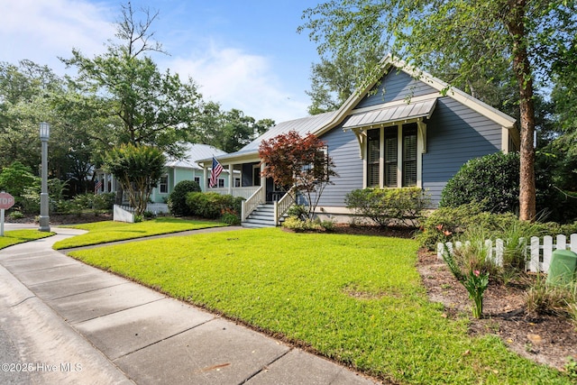 401 Fire Fly Ln, Southport, NC 28461 - bungalow-style house featuring covered porch, a front lawn, and metal roof