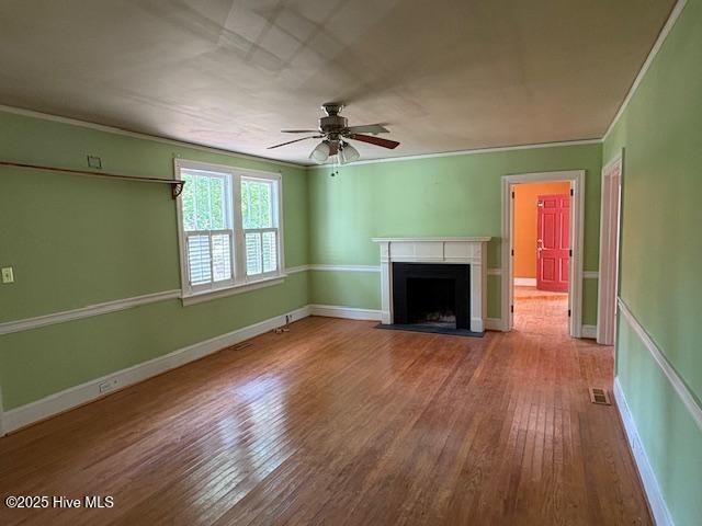 1041 Lafayette Ave, Rocky Mount, NC 27803 - unfurnished living room featuring hardwood / wood-style flooring, a fireplace with flush hearth, a ceiling fan, ornamental molding, and baseboards