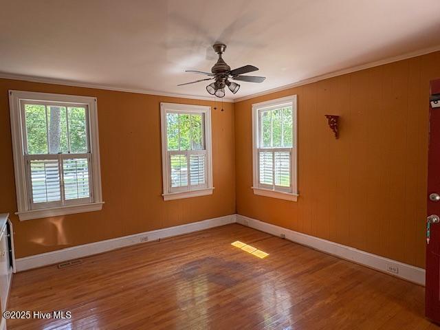 1041 Lafayette Ave, Rocky Mount, NC 27803 - unfurnished room featuring healthy amount of natural light, baseboards, wood finished floors, ceiling fan, and ornamental molding