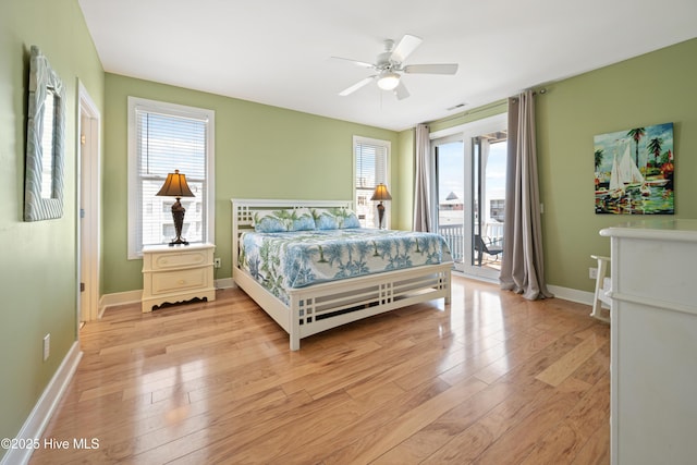 bedroom featuring access to outside, multiple windows, light wood-style floors, and a ceiling fan