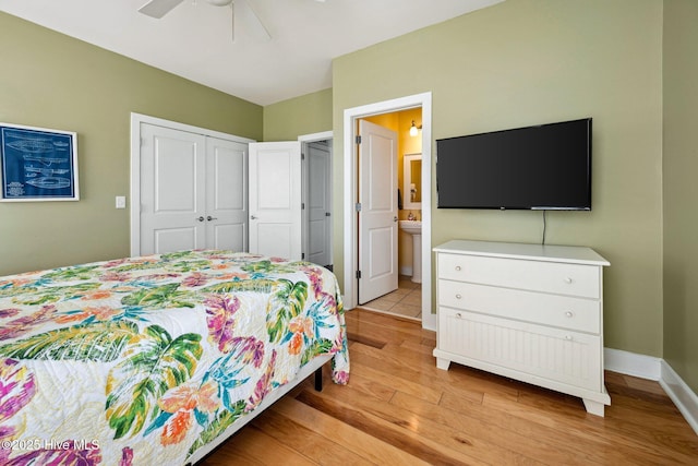 bedroom featuring light wood-type flooring, a closet, connected bathroom, and ceiling fan