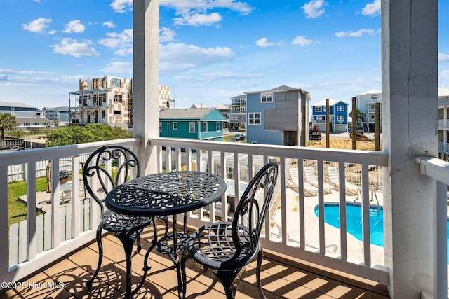 balcony with a residential view and view of pool