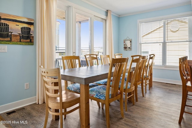 dining room with ornamental molding, healthy amount of natural light, and wood finished floors