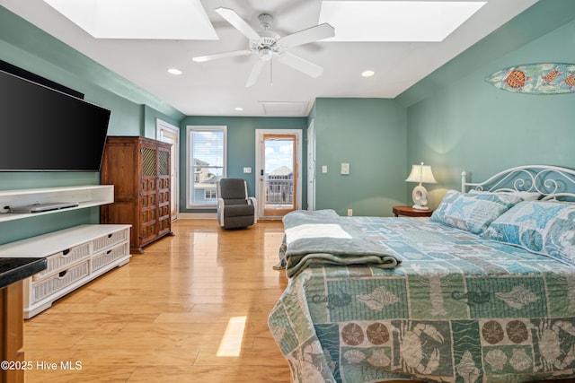 bedroom featuring a skylight, access to outside, light wood-type flooring, ceiling fan, and recessed lighting