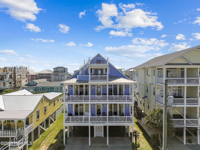 back of house with a balcony, a residential view, and a metal roof