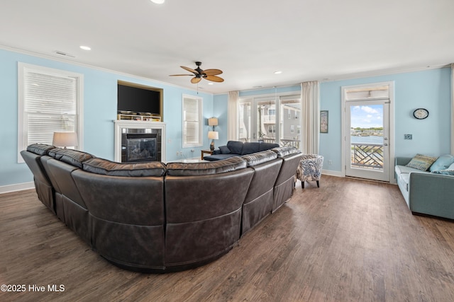 living room featuring crown molding, a tiled fireplace, ceiling fan, wood finished floors, and recessed lighting