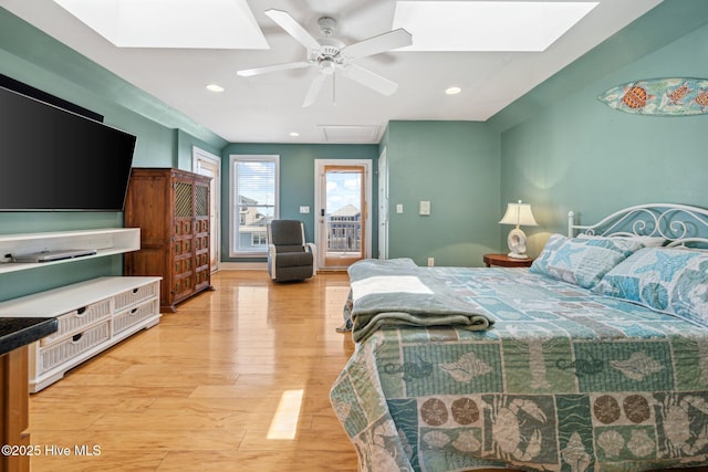 bedroom with a skylight, access to exterior, light wood-type flooring, a ceiling fan, and recessed lighting