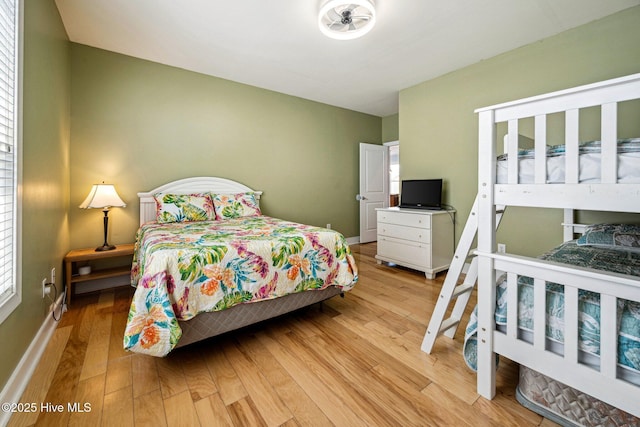 bedroom with light wood-style flooring and multiple windows