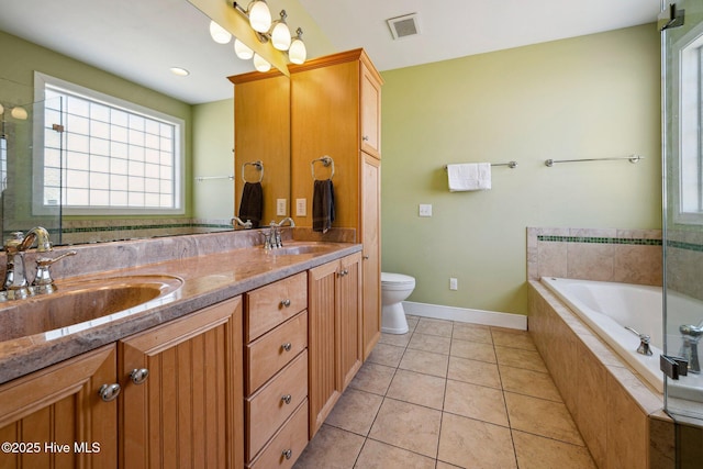 bathroom featuring double vanity, healthy amount of natural light, and a garden tub