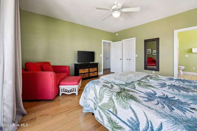 bedroom featuring connected bathroom, light wood finished floors, and a ceiling fan
