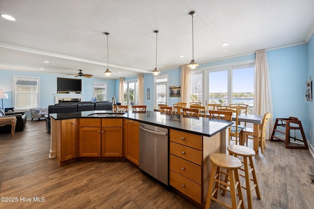 kitchen with dishwasher, open floor plan, crown molding, a kitchen breakfast bar, and dark wood finished floors