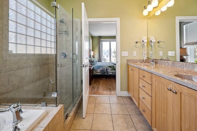 ensuite bathroom featuring double vanity, a bath, a stall shower, and tile patterned flooring