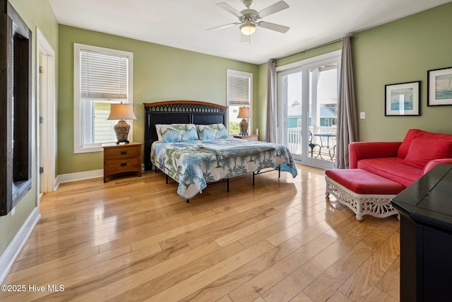 bedroom featuring access to outside, multiple windows, light wood-style flooring, and ceiling fan