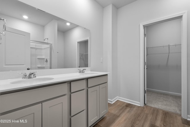 796 Palm Frond Way Unit 47, Calabash, NC 28467 - bathroom with wood finished floors, double vanity, a spacious closet, a shower, and baseboards
