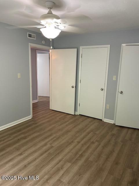 3309 Bridges St Unit 12, Morehead City, NC 28557 - unfurnished bedroom with wood finished floors, baseboards, and a ceiling fan