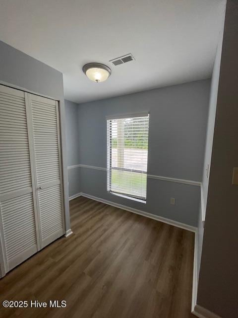 3309 Bridges St Unit 12, Morehead City, NC 28557 - unfurnished bedroom featuring a closet, wood finished floors, and baseboards