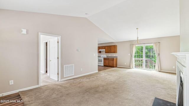 149 Edinburgh Dr, Carthage, NC 28327 - unfurnished living room with vaulted ceiling, a fireplace with flush hearth, baseboards, light carpet, and a chandelier