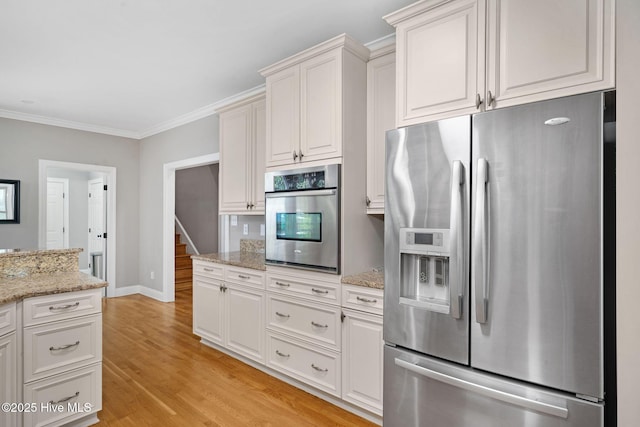 224 Red Fox Run Dr, Wallace, NC 28466 - kitchen featuring appliances with stainless steel finishes, crown molding, light wood finished floors, baseboards, and white cabinetry