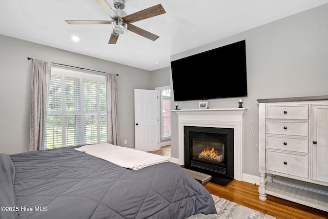 224 Red Fox Run Dr, Wallace, NC 28466 - bedroom featuring wood finished floors, a glass covered fireplace, ceiling fan, baseboards, and recessed lighting