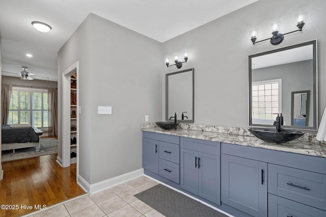 224 Red Fox Run Dr, Wallace, NC 28466 - ensuite bathroom with double vanity, a ceiling fan, a walk in closet, baseboards, and tile patterned flooring