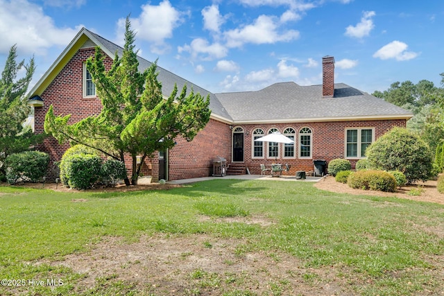 224 Red Fox Run Dr, Wallace, NC 28466 - rear view of house with brick siding, a chimney, a yard, and a patio