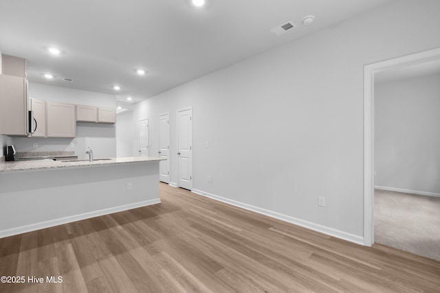 786 Palm Frond Way Unit 51, Calabash, NC 28467 - kitchen featuring light wood finished floors, a sink, recessed lighting, baseboards, and a peninsula