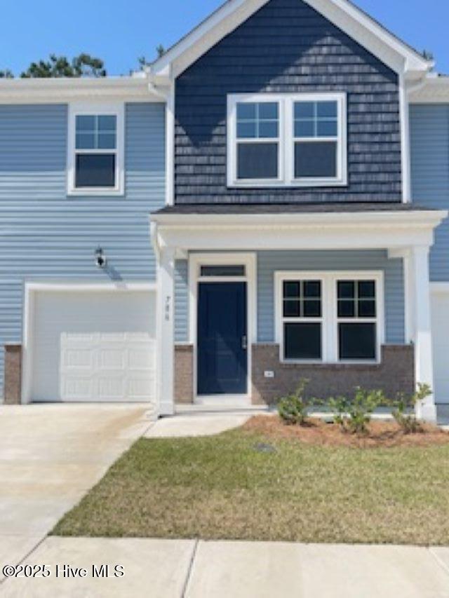 776 Palm Frond Way Unit 55, Calabash, NC 28467 - view of front of house with driveway, a garage, a front yard, brick siding, and covered porch