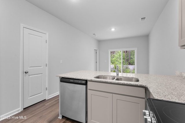 776 Palm Frond Way Unit 55, Calabash, NC 28467 - kitchen with stainless steel appliances, a sink, wood finished floors, light stone counters, and baseboards