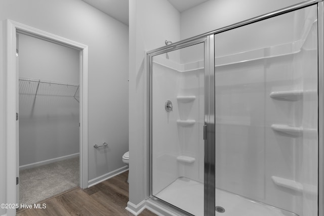 776 Palm Frond Way Unit 55, Calabash, NC 28467 - bathroom with wood finished floors, a stall shower, a walk in closet, and toilet