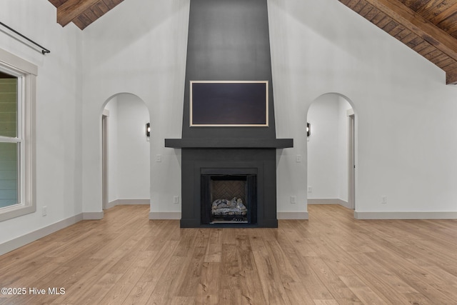 499 Longleaf Dr, West End, NC 27376 - unfurnished living room featuring wood ceiling with exposed beams, high vaulted ceiling, arched walkways, wood finished floors, and a fireplace