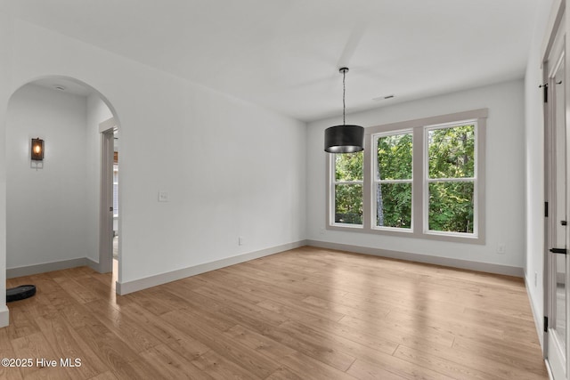 499 Longleaf Dr, West End, NC 27376 - spare room featuring arched walkways, light wood-style flooring, and baseboards