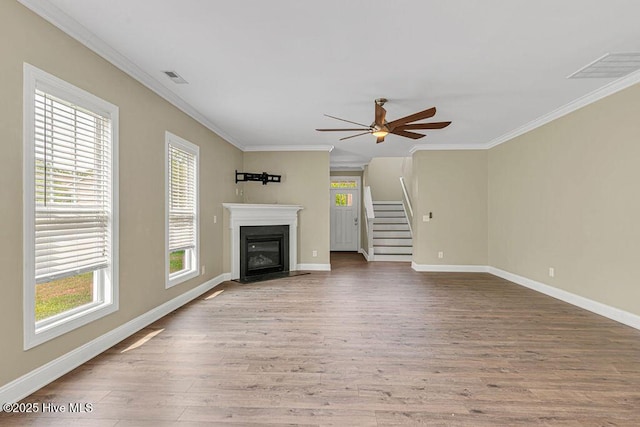472 Landsdowne Cir, Hampstead, NC 28443 - unfurnished living room featuring healthy amount of natural light, stairway, a ceiling fan, crown molding, and wood finished floors