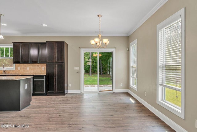 472 Landsdowne Cir, Hampstead, NC 28443 - kitchen featuring a chandelier, decorative backsplash, hanging light fixtures, light wood finished floors, and dark brown cabinetry