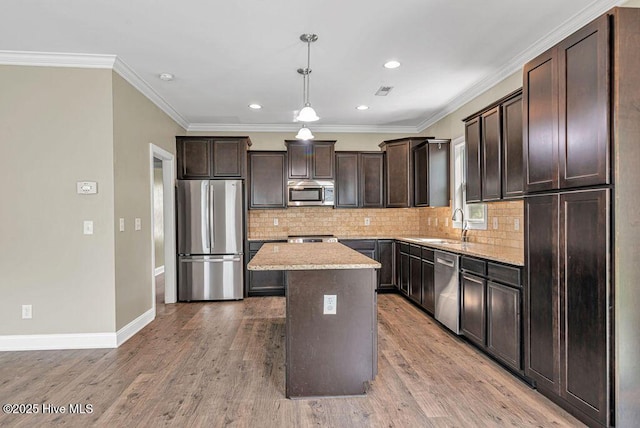 472 Landsdowne Cir, Hampstead, NC 28443 - kitchen with stainless steel appliances, dark brown cabinetry, a center island, tasteful backsplash, and light stone counters