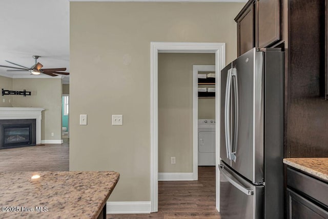 472 Landsdowne Cir, Hampstead, NC 28443 - kitchen featuring freestanding refrigerator, washer / dryer, dark brown cabinetry, dark wood-type flooring, and ceiling fan