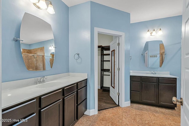 472 Landsdowne Cir, Hampstead, NC 28443 - full bath featuring two vanities, a tile shower, tile patterned floors, and baseboards