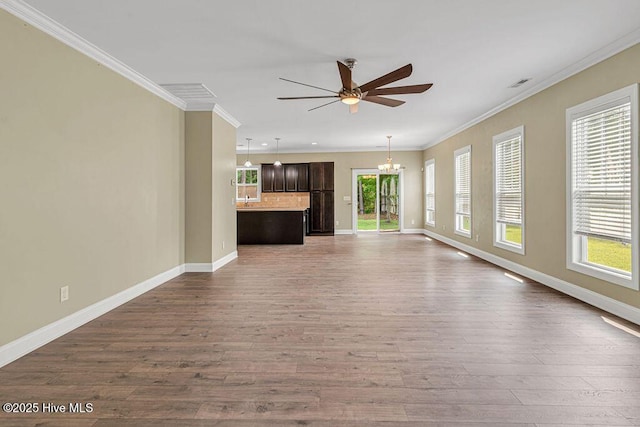 472 Landsdowne Cir, Hampstead, NC 28443 - unfurnished living room featuring a ceiling fan, a chandelier, dark wood-style floors, baseboards, and ornamental molding